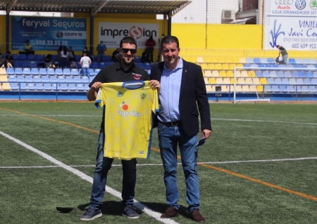 El presidente del Huétor Tájar, Luis Daza (der.), hizo entrega a Manu López, fundador de LaPreferente, de una camiseta en el descanso del partido