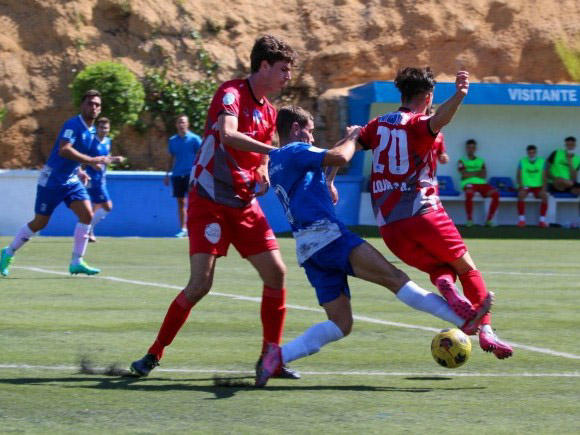 Fabio y Brian pugnan por el balón con un jugador del Monachil (ENCARNI QUESADA)
