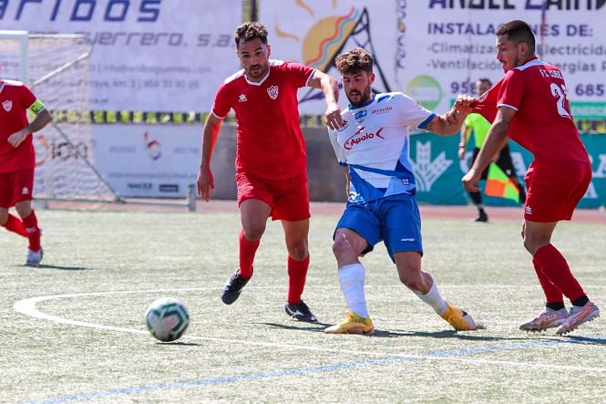 Un jugador del Loja pelea por el balón con dos jugadores del Cubillas (ENCARNI QUESADA) 