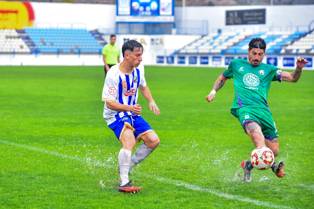 Pepe Rincón y Juanma Espinosa pelean por el balón en un encharcado césped (SEMANARIO MUCHO DEPORTE) 