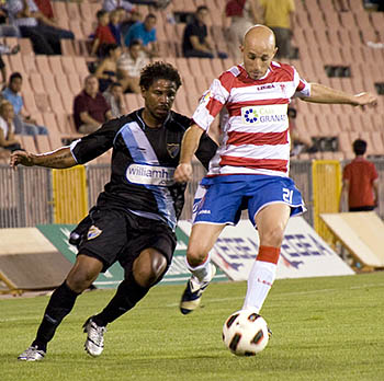 Óscar Pérez encimado por un jugador del Málaga CF (BALDOMERO) Óscar Pérez encimado por un jugador del Málaga CF (BALDOMERO)