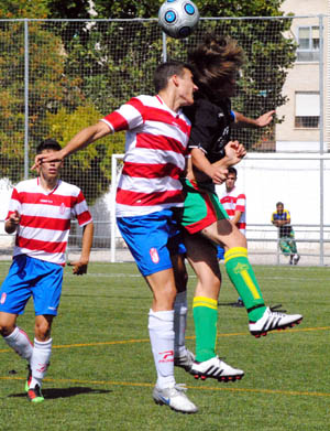 Dos jugadores rivales saltan buscando el balón (RIVERA)